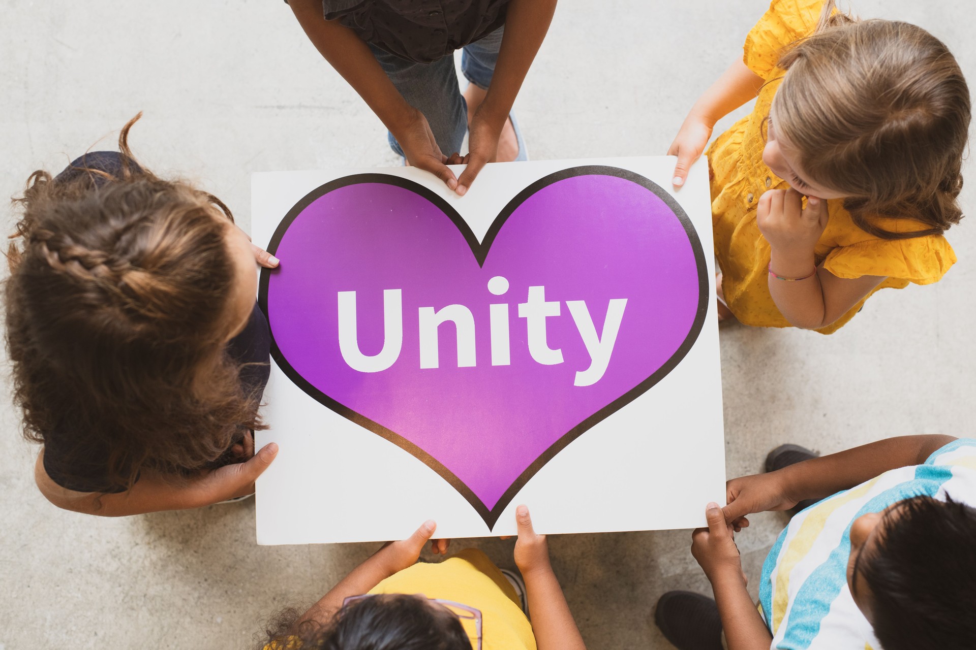 Aerial View of Multi-Ethnic Elementary Students Holding a Unity Poster stock photo
